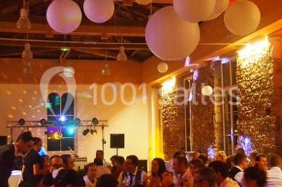 Paysage rural avec des arbres, des collines verdoyantes et une toiture en bois au premier plan sous une lumière douce.