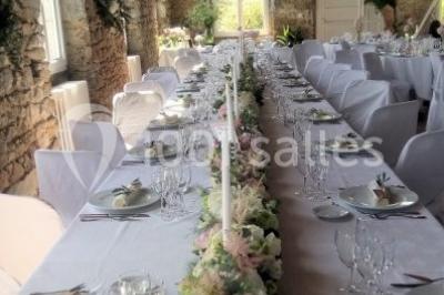 Paysage rural avec des arbres, des collines verdoyantes et une toiture en bois au premier plan sous une lumière douce.