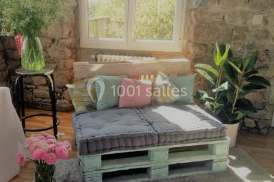 Paysage rural avec des arbres, des collines verdoyantes et une toiture en bois au premier plan sous une lumière douce.