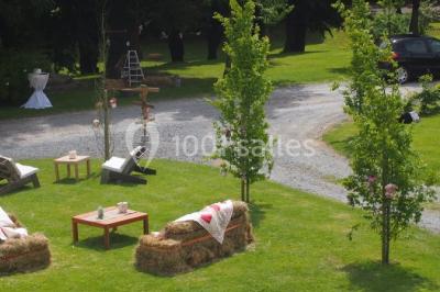Paysage rural avec des arbres, des collines verdoyantes et une toiture en bois au premier plan sous une lumière douce.
