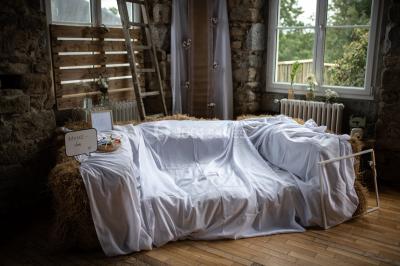Paysage rural avec des arbres, des collines verdoyantes et une toiture en bois au premier plan sous une lumière douce.