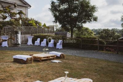 Paysage rural avec des arbres, des collines verdoyantes et une toiture en bois au premier plan sous une lumière douce.