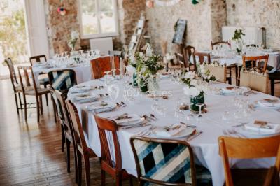 Paysage rural avec des arbres, des collines verdoyantes et une toiture en bois au premier plan sous une lumière douce.