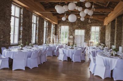 Paysage rural avec des arbres, des collines verdoyantes et une toiture en bois au premier plan sous une lumière douce.