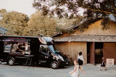 Paysage rural avec des arbres, des collines verdoyantes et une toiture en bois au premier plan sous une lumière douce.