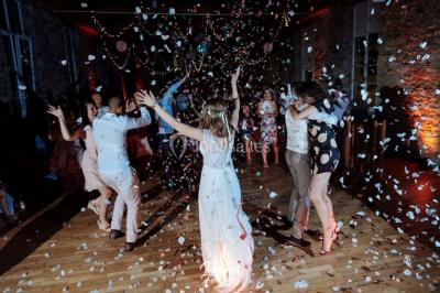 Paysage rural avec des arbres, des collines verdoyantes et une toiture en bois au premier plan sous une lumière douce.