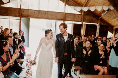 Paysage rural avec des arbres, des collines verdoyantes et une toiture en bois au premier plan sous une lumière douce.