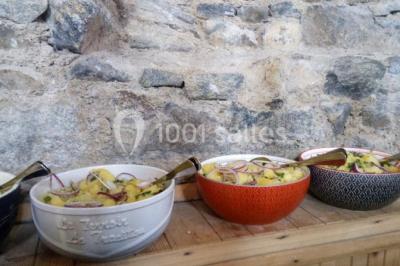 Vue d'un espace extérieur avec pelouse, arbres, une voiture ancienne rouge et des personnes se promenant.