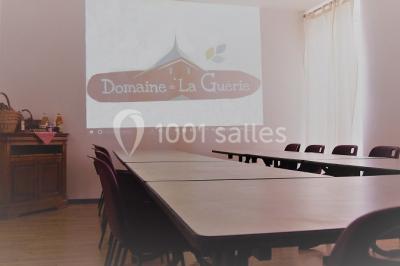 Vue d'un espace extérieur avec pelouse, arbres, une voiture ancienne rouge et des personnes se promenant.