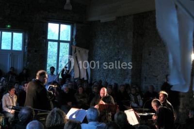 Vue d'un espace extérieur avec pelouse, arbres, une voiture ancienne rouge et des personnes se promenant.