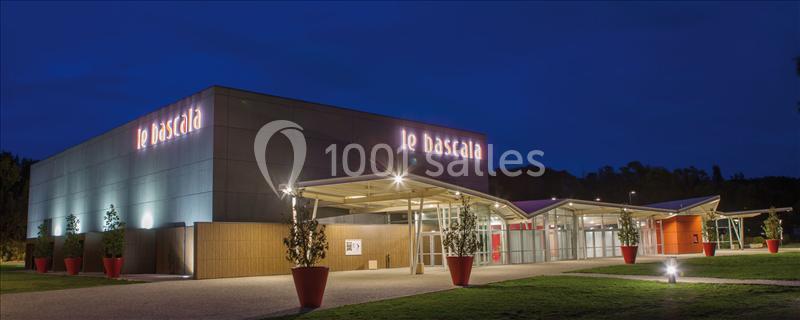 Façade éclairée d'un bâtiment moderne nommé ’Le Bascala’ avec une entrée vitrée, de nuit.