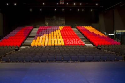 Parking vide devant un bâtiment moderne gris avec l'enseigne ’Le Dastala’ et des arbres en arrière-plan.