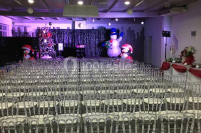 Un parking extérieur rempli de voitures, entouré de végétation et éclairé par une lumière naturelle.