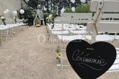 Un parking extérieur rempli de voitures, entouré de végétation et éclairé par une lumière naturelle.