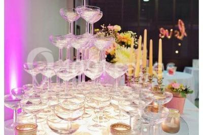 Un parking extérieur rempli de voitures, entouré de végétation et éclairé par une lumière naturelle.