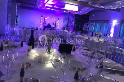 Un parking extérieur rempli de voitures, entouré de végétation et éclairé par une lumière naturelle.