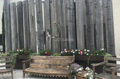 Un parking extérieur rempli de voitures, entouré de végétation et éclairé par une lumière naturelle.