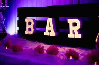 Un parking extérieur rempli de voitures, entouré de végétation et éclairé par une lumière naturelle.