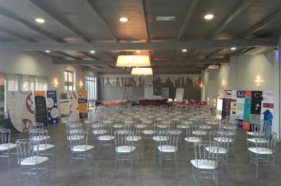 Un parking extérieur rempli de voitures, entouré de végétation et éclairé par une lumière naturelle.