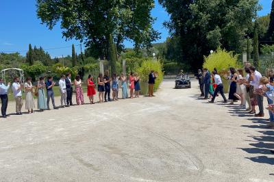 Un parking extérieur rempli de voitures, entouré de végétation et éclairé par une lumière naturelle.