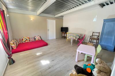 Un parking extérieur rempli de voitures, entouré de végétation et éclairé par une lumière naturelle.