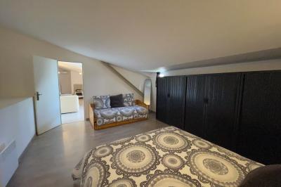 Un parking extérieur rempli de voitures, entouré de végétation et éclairé par une lumière naturelle.