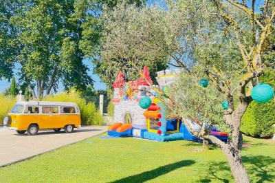 Un parking extérieur rempli de voitures, entouré de végétation et éclairé par une lumière naturelle.