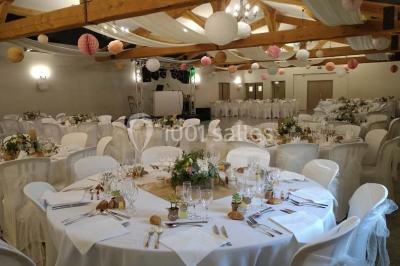 Décoration champêtre avec canapé, fauteuils, bottes de paille et guirlandes dans un jardin verdoyant.