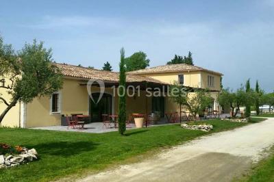 Décoration champêtre avec canapé, fauteuils, bottes de paille et guirlandes dans un jardin verdoyant.