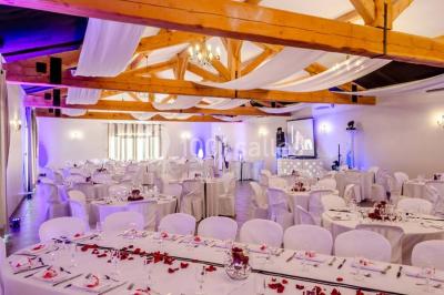 Décoration champêtre avec canapé, fauteuils, bottes de paille et guirlandes dans un jardin verdoyant.