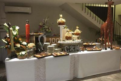 Décoration champêtre avec canapé, fauteuils, bottes de paille et guirlandes dans un jardin verdoyant.