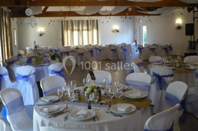 Décoration champêtre avec canapé, fauteuils, bottes de paille et guirlandes dans un jardin verdoyant.