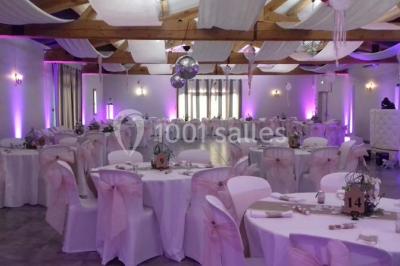 Décoration champêtre avec canapé, fauteuils, bottes de paille et guirlandes dans un jardin verdoyant.