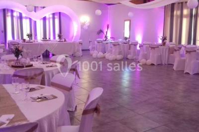 Décoration champêtre avec canapé, fauteuils, bottes de paille et guirlandes dans un jardin verdoyant.