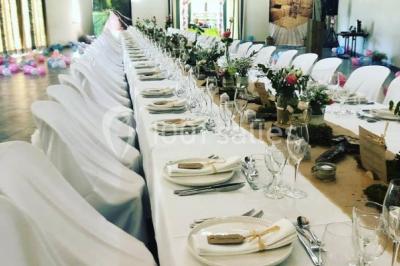 Décoration champêtre avec canapé, fauteuils, bottes de paille et guirlandes dans un jardin verdoyant.