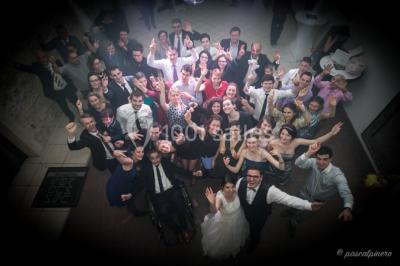 Un couple en tenue de mariage s'embrasse dans un jardin, avec des arbres en arrière-plan.