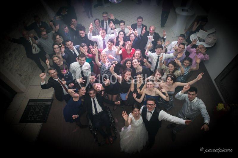 Groupe de personnes souriantes posant pour une photo de fête, vu en plongée dans une ambiance conviviale.