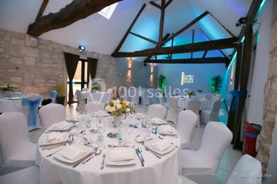 Un couple en tenue de mariage s'embrasse dans un jardin, avec des arbres en arrière-plan.