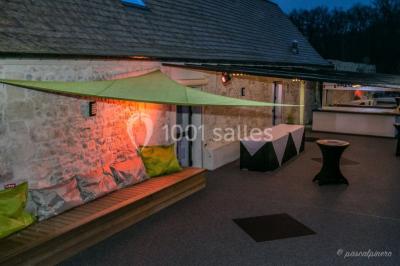 Un couple en tenue de mariage s'embrasse dans un jardin, avec des arbres en arrière-plan.