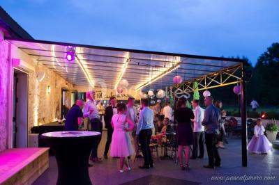 Un couple en tenue de mariage s'embrasse dans un jardin, avec des arbres en arrière-plan.
