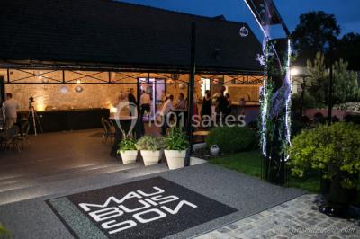 Un couple en tenue de mariage s'embrasse dans un jardin, avec des arbres en arrière-plan.