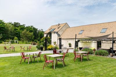 Un couple en tenue de mariage s'embrasse dans un jardin, avec des arbres en arrière-plan.