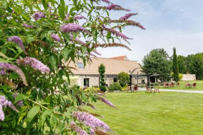 Un couple en tenue de mariage s'embrasse dans un jardin, avec des arbres en arrière-plan.
