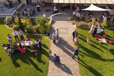 Un couple en tenue de mariage s'embrasse dans un jardin, avec des arbres en arrière-plan.
