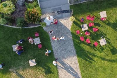 Un couple en tenue de mariage s'embrasse dans un jardin, avec des arbres en arrière-plan.