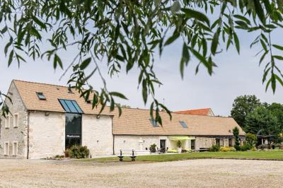 Un couple en tenue de mariage s'embrasse dans un jardin, avec des arbres en arrière-plan.