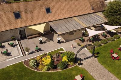 Un couple en tenue de mariage s'embrasse dans un jardin, avec des arbres en arrière-plan.