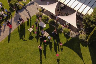 Un couple en tenue de mariage s'embrasse dans un jardin, avec des arbres en arrière-plan.