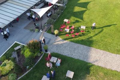 Un couple en tenue de mariage s'embrasse dans un jardin, avec des arbres en arrière-plan.