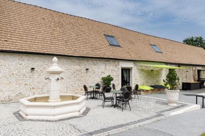 Un couple en tenue de mariage s'embrasse dans un jardin, avec des arbres en arrière-plan.